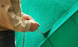 man holding rope to a tent