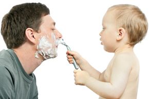 boy shaving father