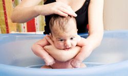 Mother bathing infant