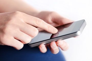 woman's hands using touch screen on smartphone