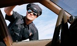 cop peering into window of pulled over vehicle