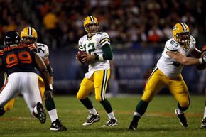 绿湾包装工队的亚伦·罗杰斯（Aaron Rodgers）准备通过2010年对阵芝加哥熊队的比赛。“border=