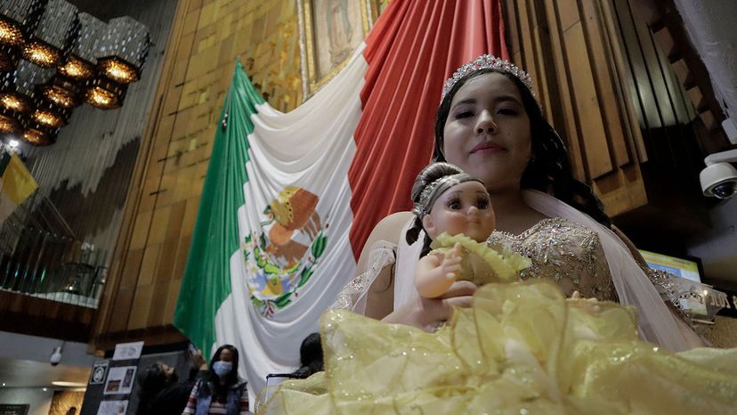 quinceañera poses with her symbolic doll