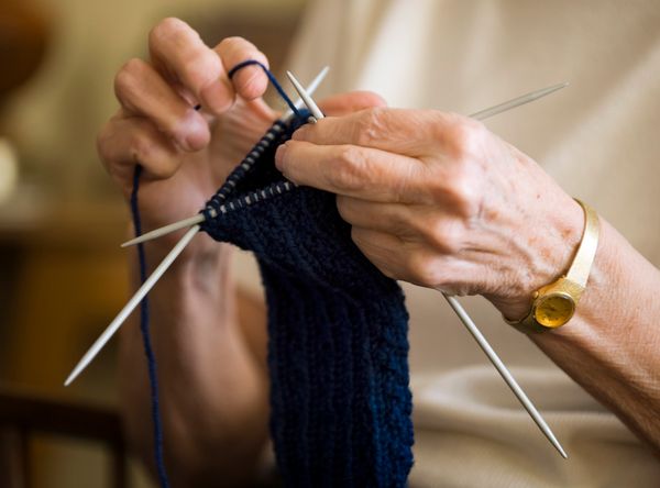 A woman knits mittens.