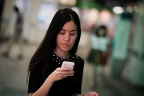 A woman looks at her smartphone.