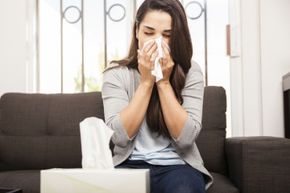 A woman blows her nose.