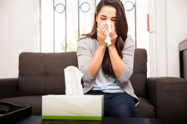 A woman blows her nose.