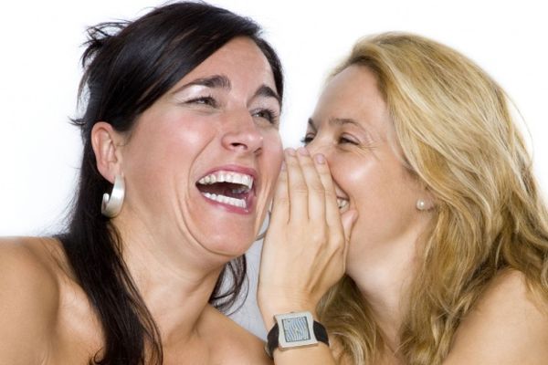 Two women whispering gossip.
