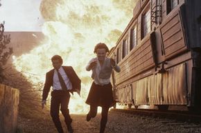 Pierce Brosnan (as the ever-suave James Bond) and Izabella Scorupco flee from an exploding train in the movie "Goldeneye.