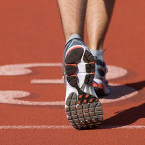 Athlete running on sports track in sport shoe.