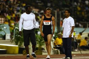 英国短跑运动员蒂姆·本杰明(中)在2009年牙买加国际邀请赛男子400米比赛中拉伤腿筋后离开跑道。＂border=