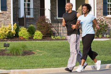 happy couple jogs through neighborhood