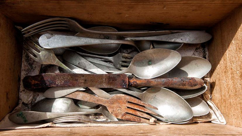 Old, rusty utensils in a wooden box.