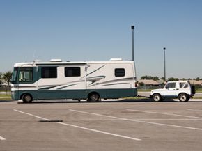 A large RV towing a small vehicle