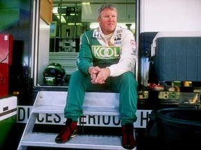 Paul Tracy sitting on the steps of a race car trailer