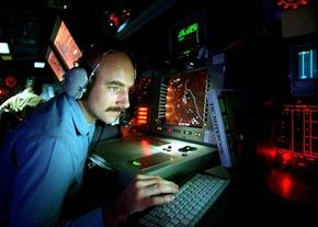 Operation Specialist 2nd Class Gilbert Lundgren operates radar equipment in the combat information center of the USS Carney.