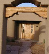 The wooden front door of a rammed earth house.