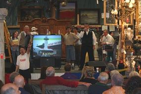 TV monitors are used to give bidders an up-close glimpse of items outdoors and on the auction floor.