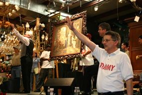 Auctioneers guide the sale of one of the pieces of art auctioned at Red Baron's Antiques.