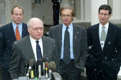 Politician in suit speaking into microphone.