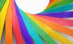 Wooden colored craft sticks, in rainbow colors, arranged in a sweeping spiral pattern.