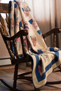 Old wooden rocker, draped with a cozy handmade quilt. Backlighting from a sunny window.