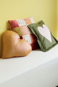 Group of 3 home made pillows on a bench.