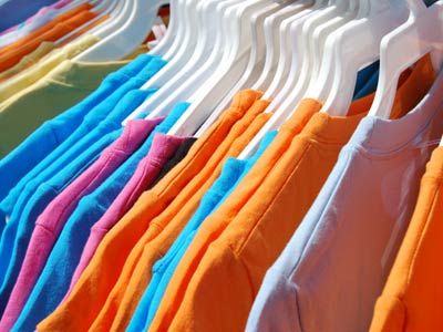 Colorful t-shirts on a flea market clothing rack.