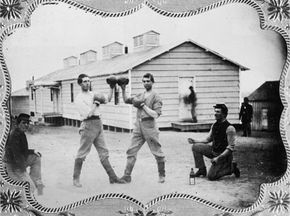 Two pugilists touch gloves outside their barracks, circa 1865