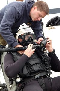 Evan Colbert中尉在秘鲁利马潜水前接受MK-16换气器的帮助。军方长期以来一直在使用呼吸器。＂width=