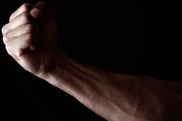 Man's arm on black background