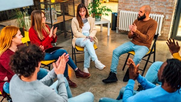 A woman sharing on a group of people.