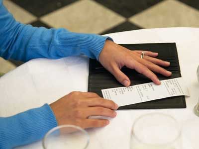 Woman checking final bill at restaurant.