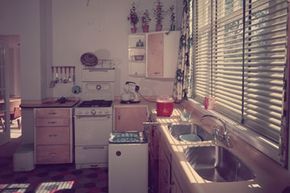 Here's a fully fitted retro kitchen, complete with stove, washing machine, double sink unit and electric mixer.