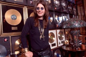 Ozzy Osbourne posing at home with his gold discs.