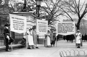 Several demonstrators dressed as pilgrims carry placards calling for the release of political prisoners in front of the White House, ca. 1919.