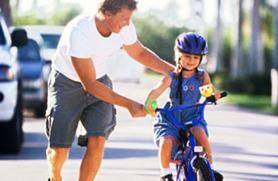 father teaching daughter how to ride a bikefather