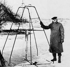 Dr. Robert H. Goddard and his liquid oxygen-gasoline rocket in the frame from which it was fired on March 16, 1926, at Auburn, Mass. It flew for only 2.5 seconds, climbed 41 feet, and landed 184 feet away in a cabbage patch.