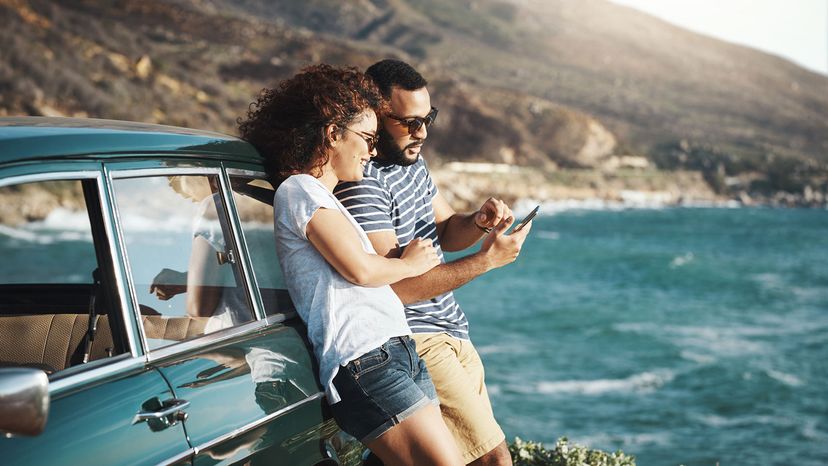 couple looking at phone by beach