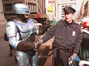 尽管一些当前警察机器人可以在街上巡逻,他们not nearly as animated as the character from "RoboCop" seen here at the Toy Fair in New York City. See more robot images.”width=