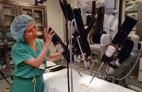 A nurse prepares a robotic surgery system for heart surgery.
