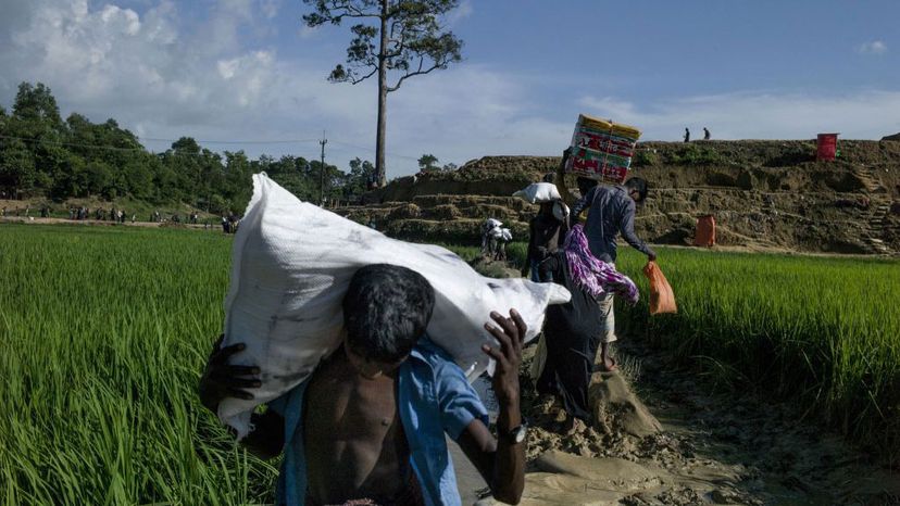 Rohingya Muslim refugees holds bags of goods as they reach Balukhali refugee camp by the field in Bangladesh's Ukhiya district on October 4, 2017.  Thousands now cross the border each day.  FRED DUFOUR/AFP/Getty Images