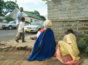 A blind woman and her daughter ask for money from passersby in Blantyre, Malawi. One of the Rotary Club’s seven priorities is providing service to people in need.