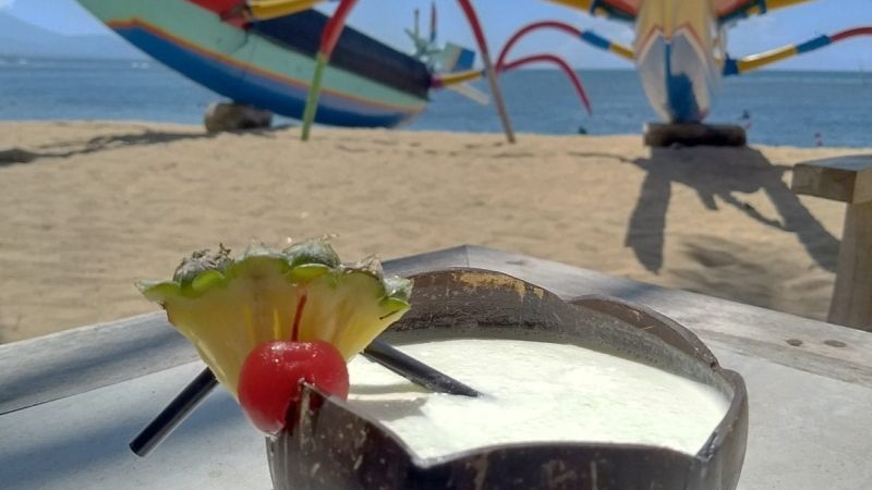 Enjoying a fresh pina colada on the beach in Sanur, Bali.