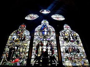 The sun shines through stained glass windows depicting the construction of Southwark Cathedral August 8, 2003, in London, England.