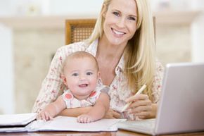 Mother and child sitting in front of computer and other work.