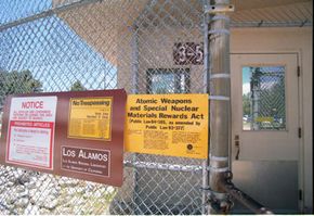 Signs posted on the gated wall around the main technical area of Los Alamos National Laboratory keep visitors informed about security.