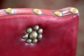 brass studs on antique red chair