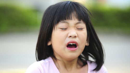 Why does tickling the roof of your mouth with your tongue stifle a sneeze?
