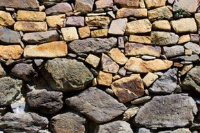 strata of a dry stone wall showing larger stones at the base